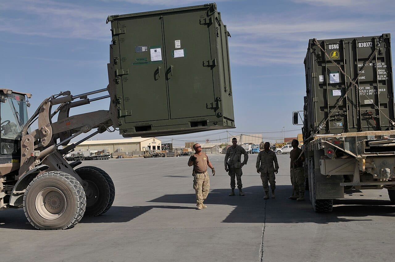 US Navy 091128-N-9584H-034 A Seabee guides an airfield ground crew loading equipment onto a truck on the Kandahar Airfield flightline