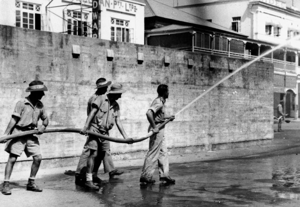 StateLibQld 1 127567 Soldiers manning a fire hose during fire brigade practise, Cairns, ca. 1942