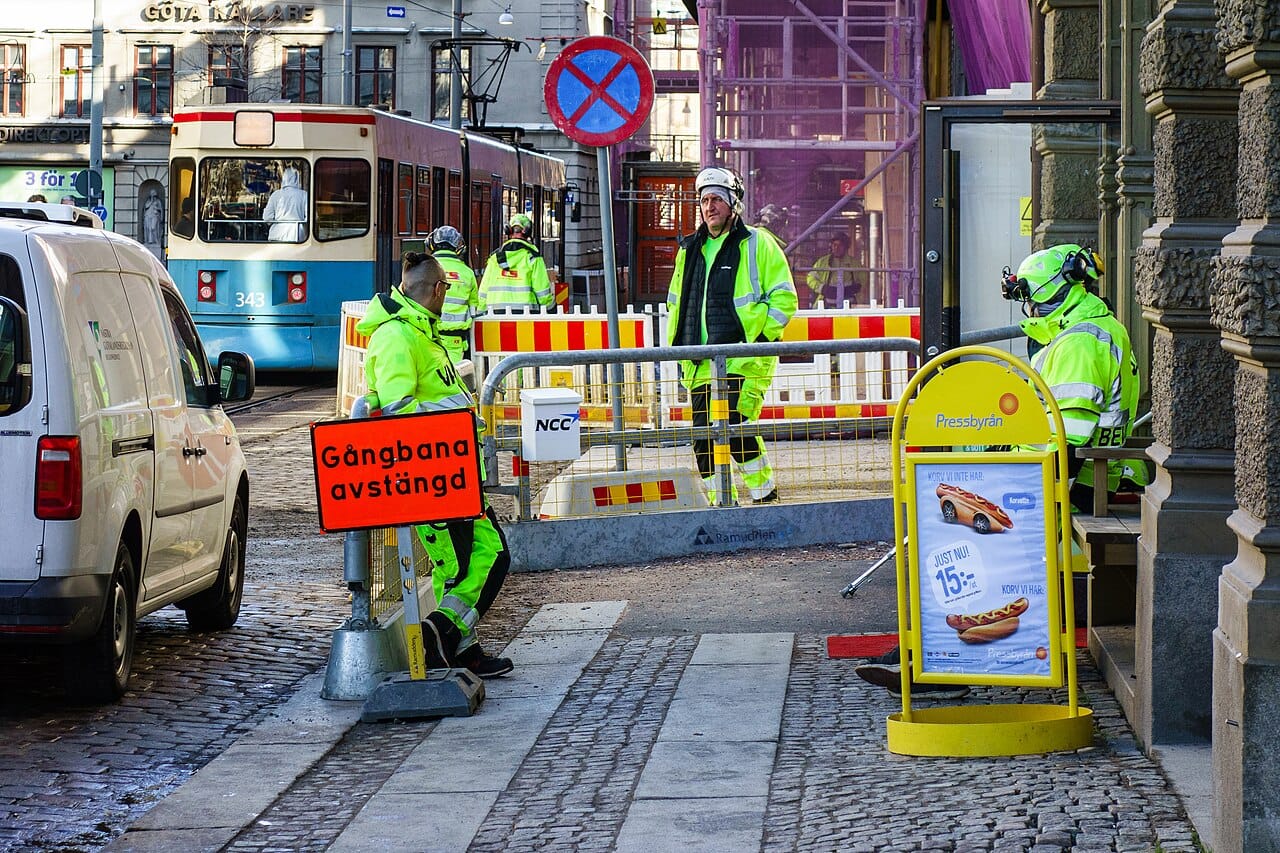 Tram-track works on a city street, the crew in yellow-green.