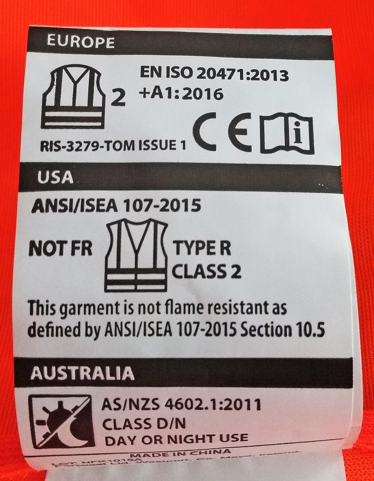 The sewn-in label of a high-visibility vest, listing EN ISO 20471, ANSI/ISEA 107 and AS/NZS 4602.1.