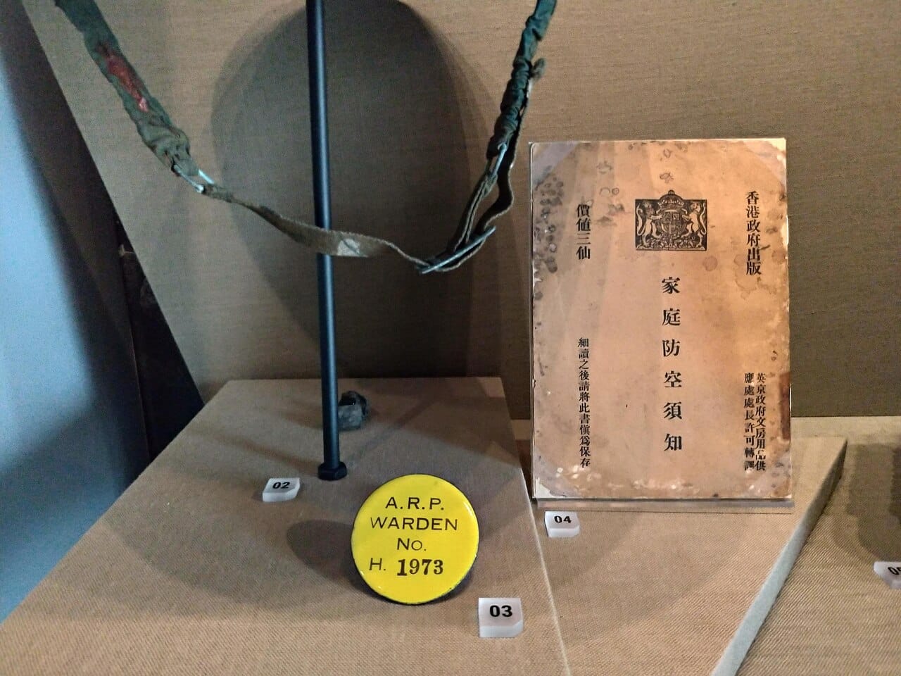 Air Raid Precautions Department warden badge, air defence instructions for families issued by the British Hong Kong government