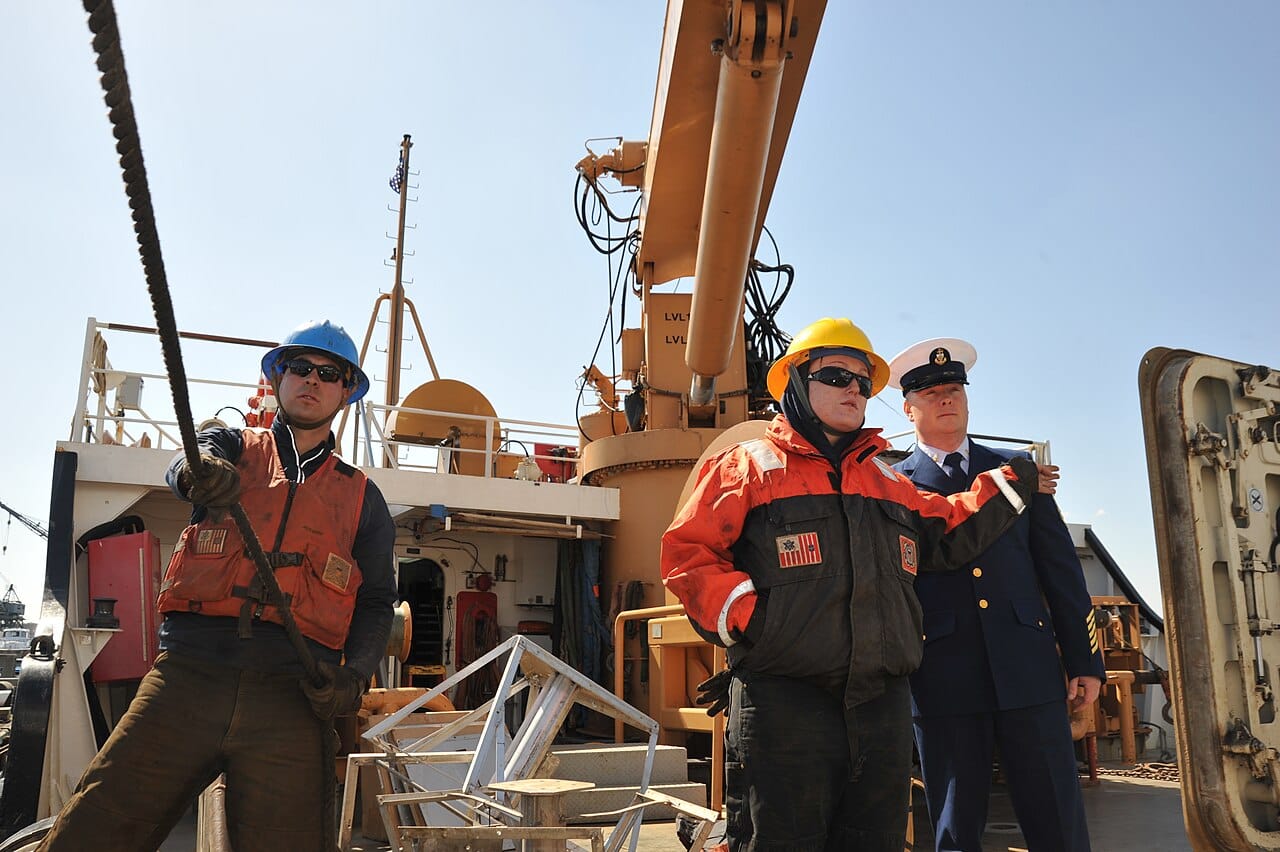 U.S. Coast Guard Chief Petty Officer Andrew Pierce, right, the first lieutenant aboard the cutter USCGC James Rankin (WLM 555), watches as crew members move equipment off the deck in Curtis Bay, Md., April 3 130403-G-MD940-035