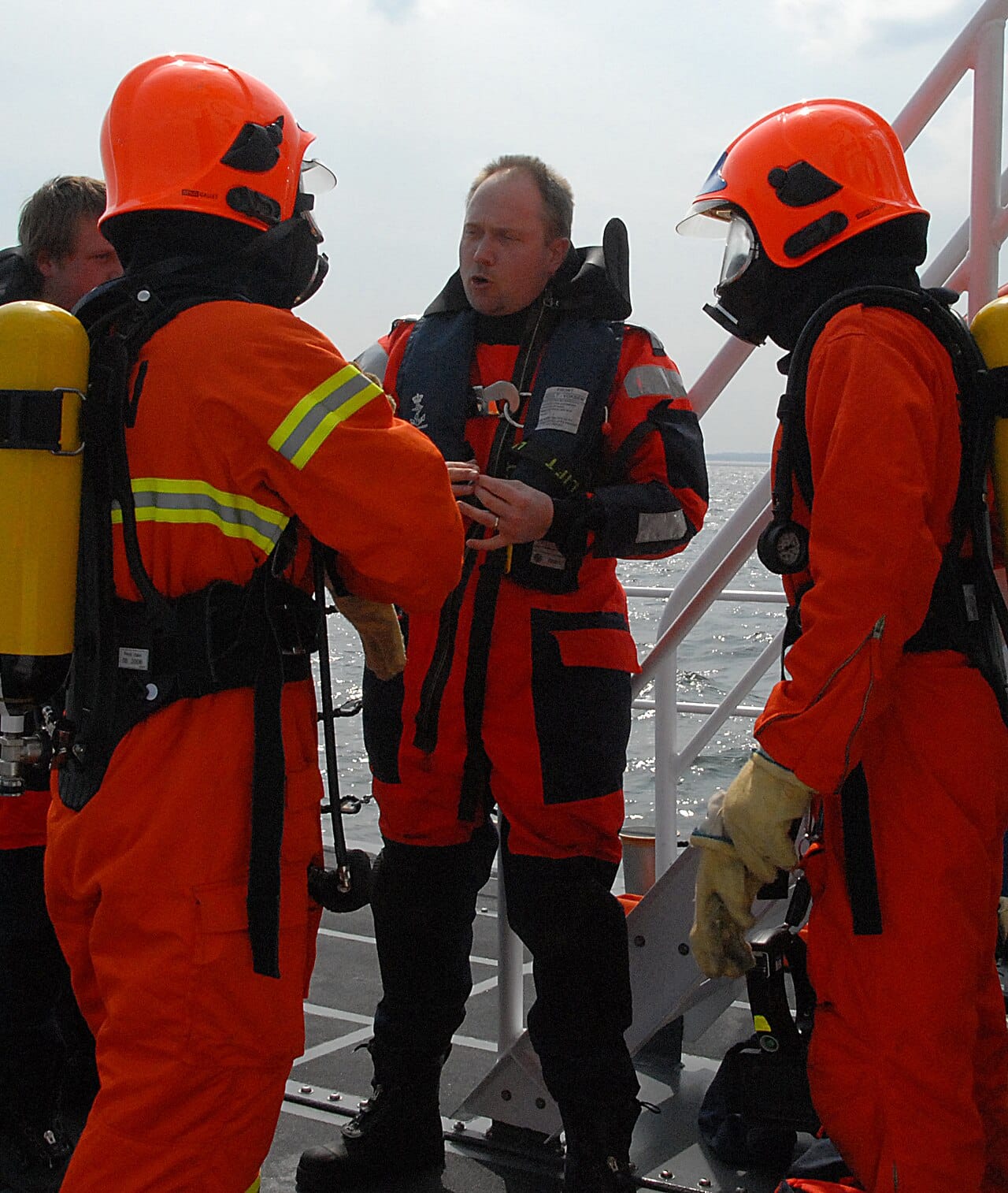 A Danish naval distress team in orange immersion suits.
