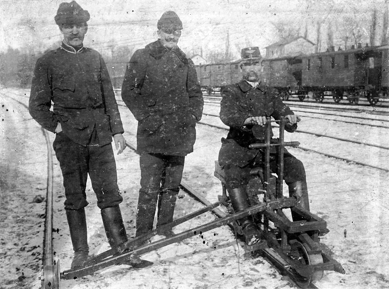 Railway staff at a station in winter, snow on the rails.