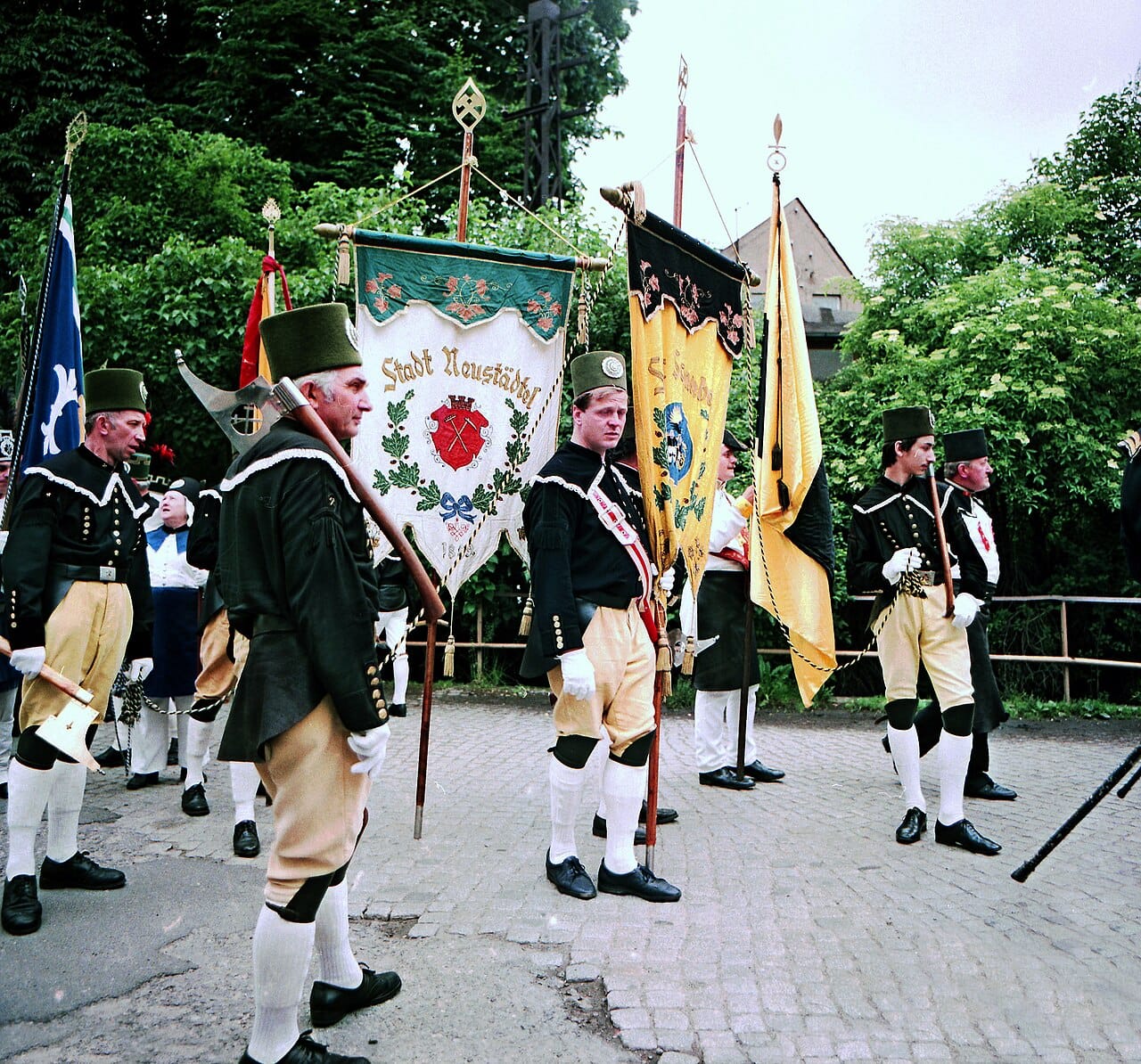 A group in green and black behind a guild banner.