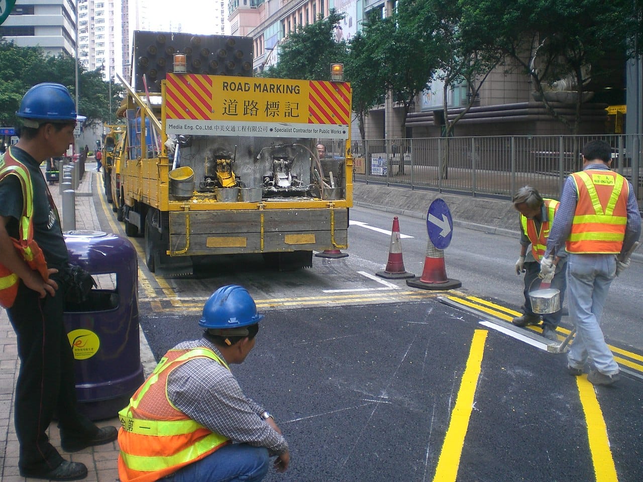 Road marking in Hong Kong, vests over ordinary clothes.