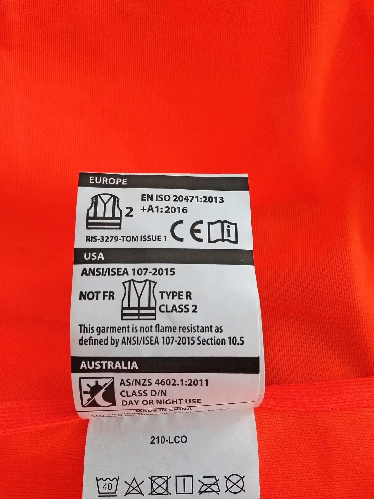 The same markings photographed against the orange of the garment itself.