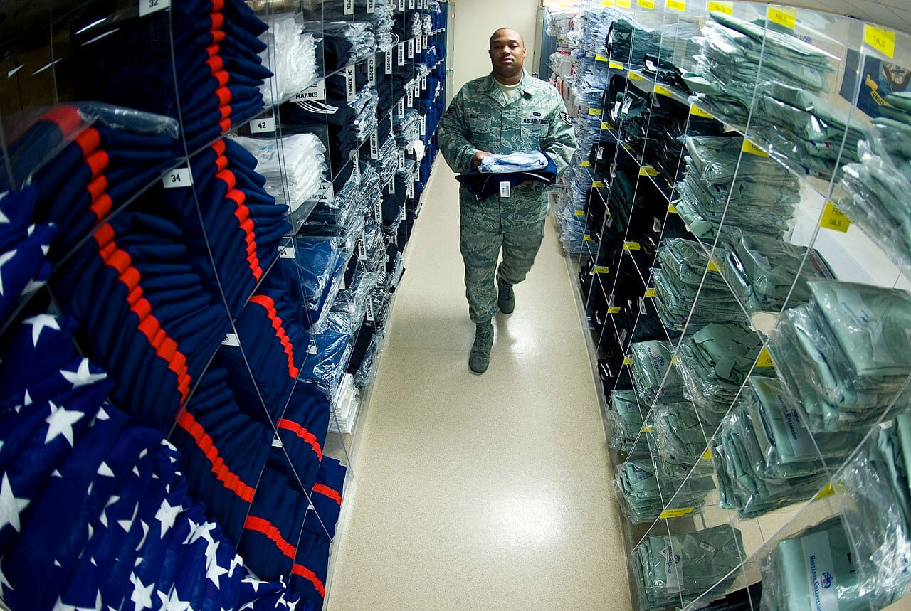 Rows of military service dress uniforms hanging in storage.