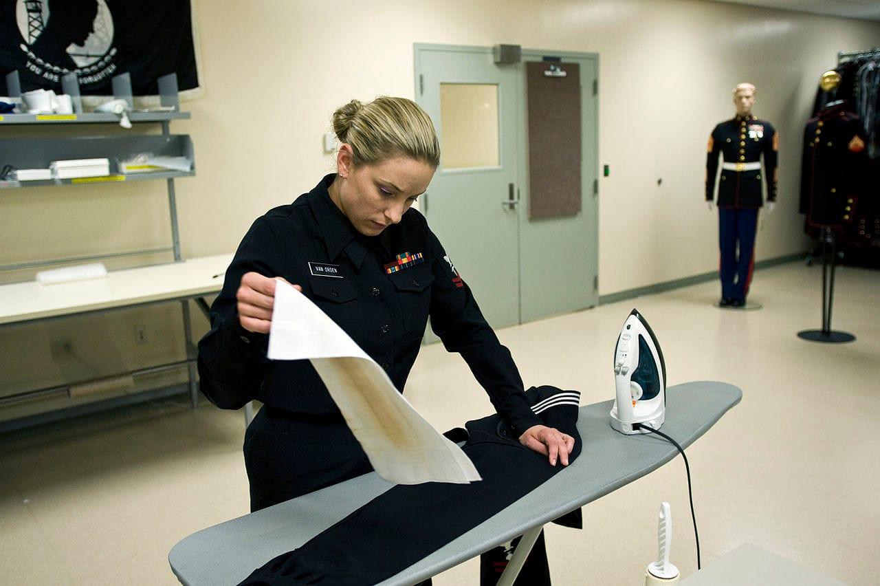 A sailor ironing a uniform.